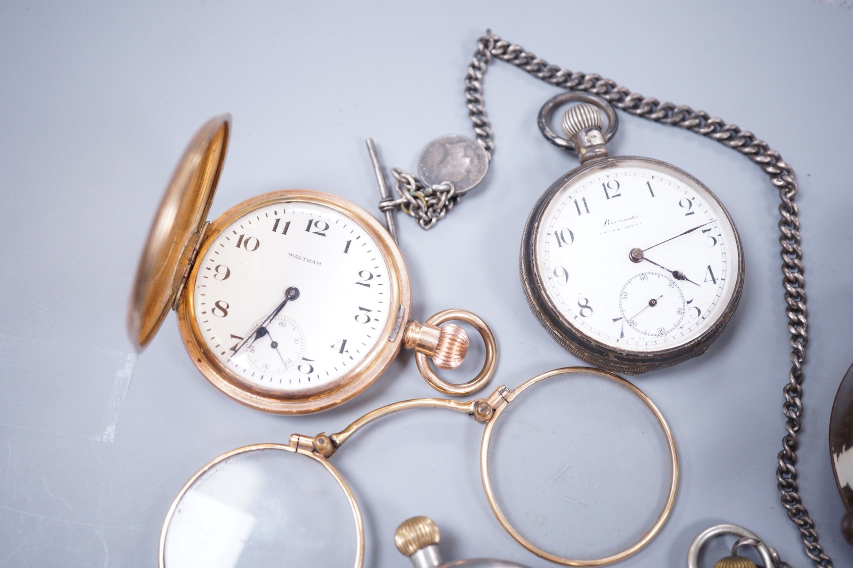 A small collection of six assorted pocket watches, including a silver open face, gun metal on a silver albert and gold plated, a Estyma alarm clock and a pair of gold plated lorgnettes.